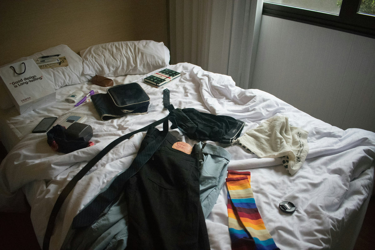 An unmade bed in late morning light, the room already bright
