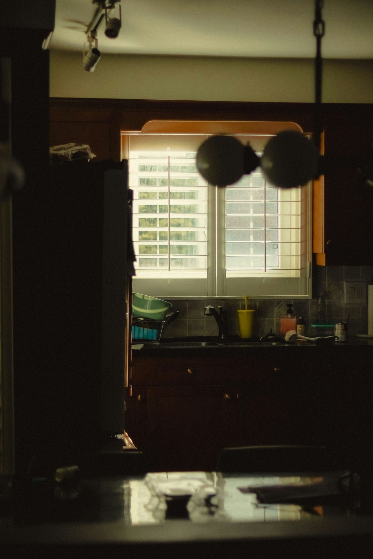 A tub of Walt & Co creatine and a full glass of water on a kitchen counter in early morning light